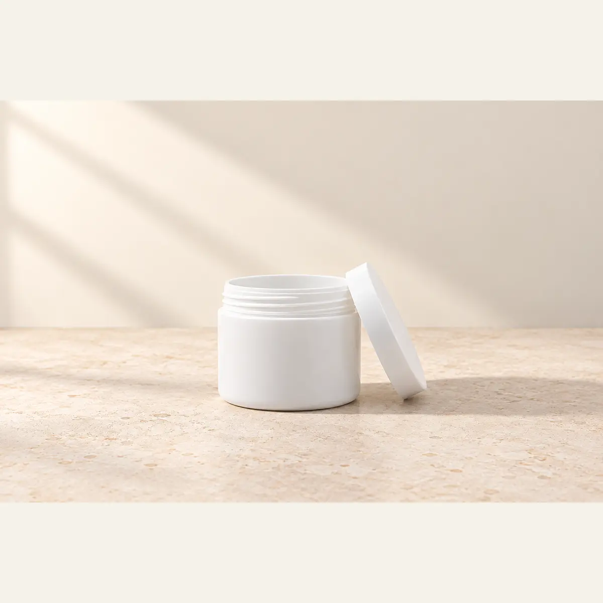 White 50 g Cosmetic Jar · White Lid photographed on a warm neutral studio background