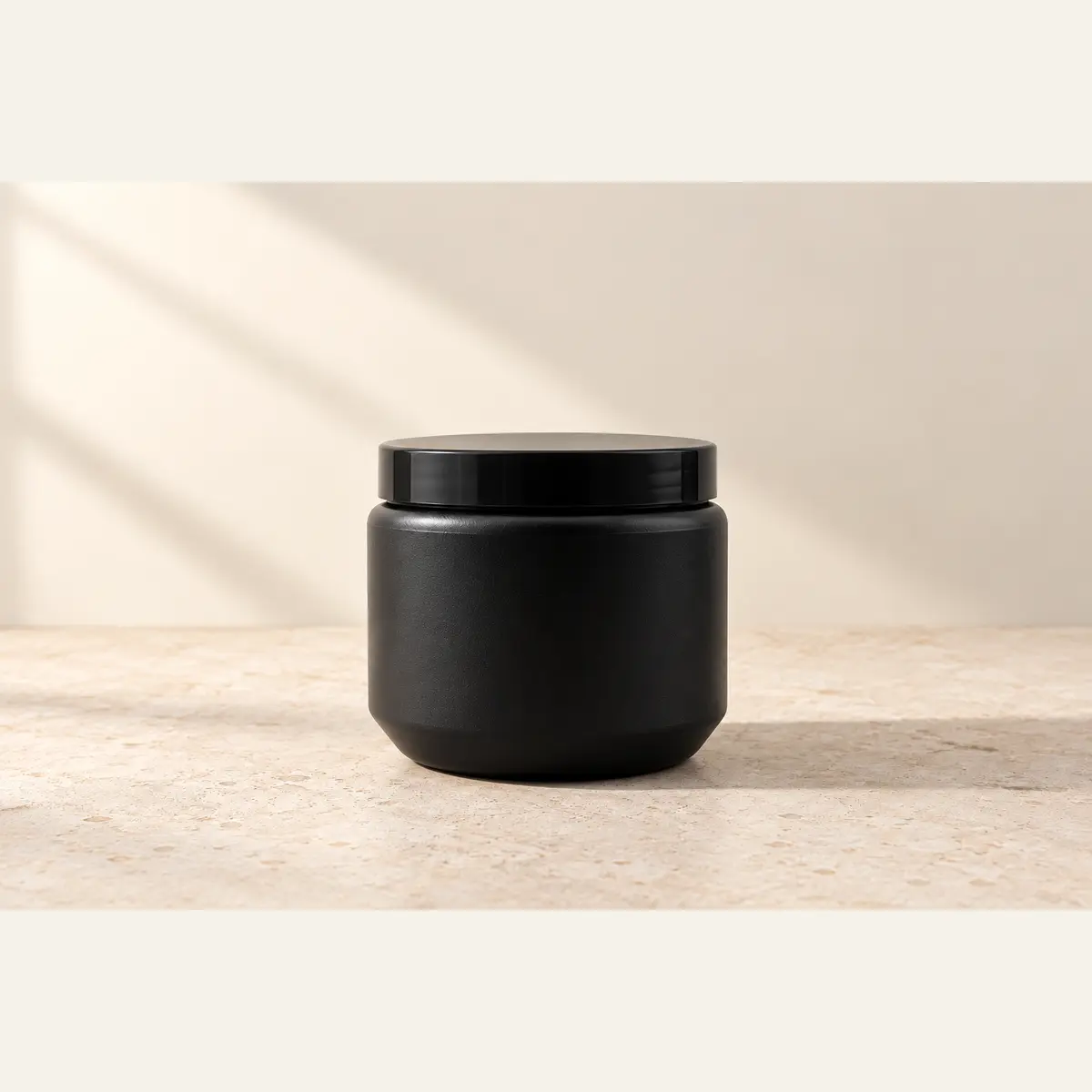 Black 500 g HDPE Jar photographed on a warm neutral studio background