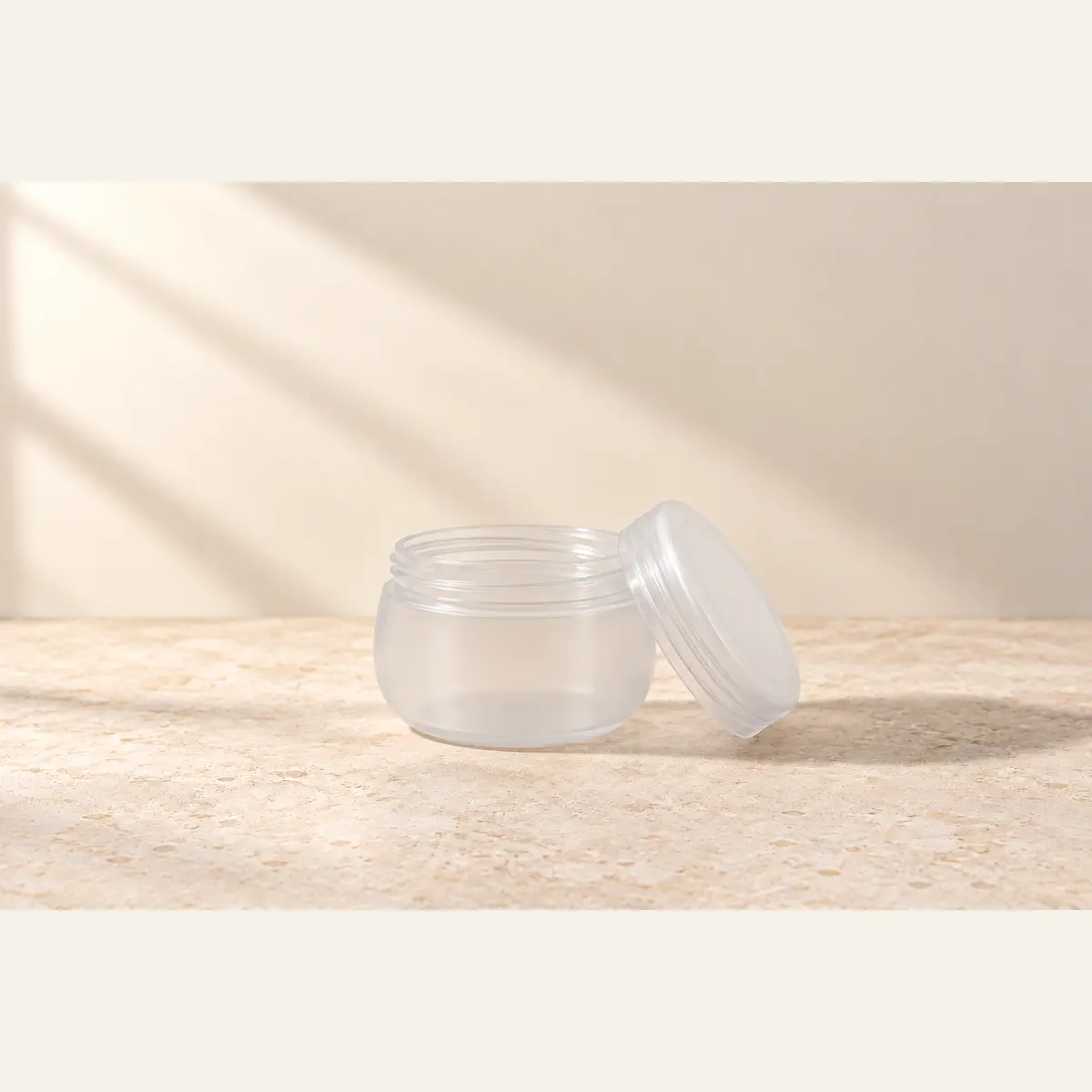 Rounded Natural Cream Jar photographed on a warm neutral studio background