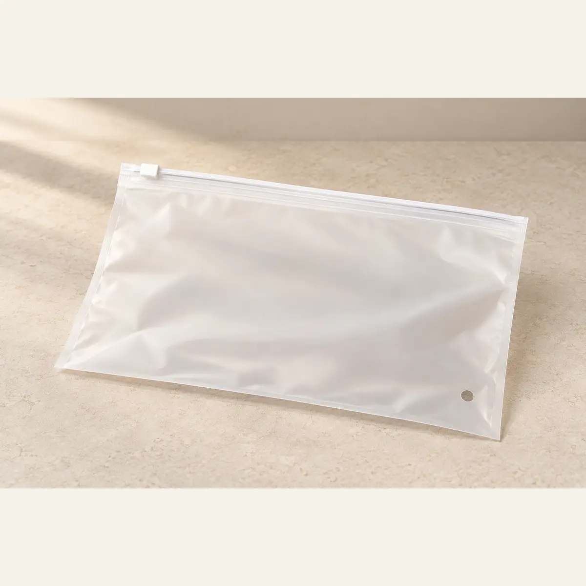 Frosted Clothing Zipper Bag photographed on a warm neutral studio background