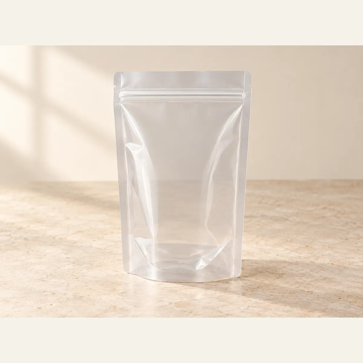 Clear Stand-Up Zipper Pouch · 12 × 18 + 8 cm photographed on a warm neutral studio background