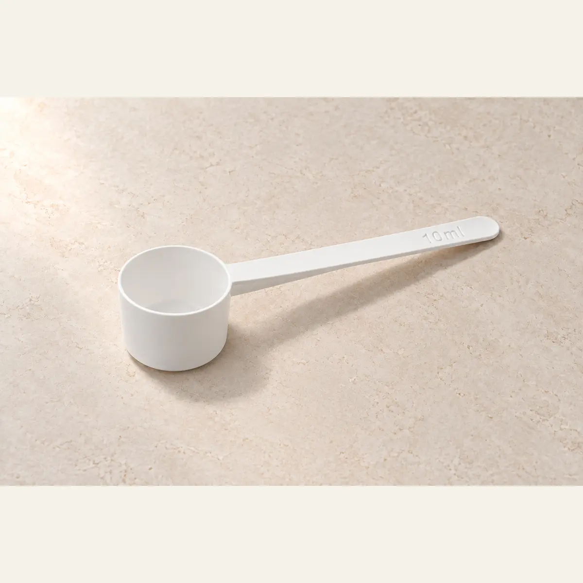 White Powder Scoop photographed on a warm neutral studio background
